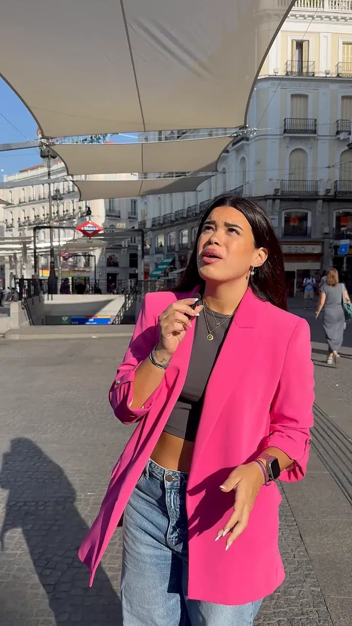 En la Puerta del Sol de Madrid, una chica le habla a cámara junto a la estatua del Oso y el Madroño.