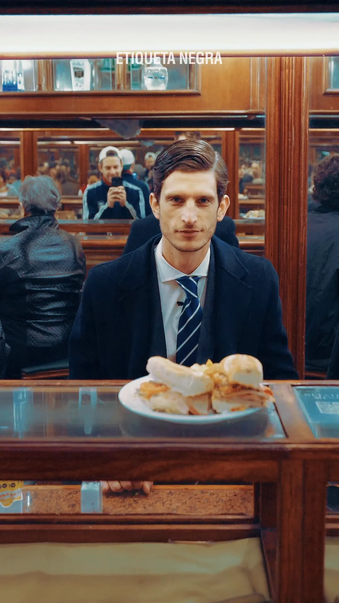 Un hombre de traje come un sándwich en la barra de Paulin.